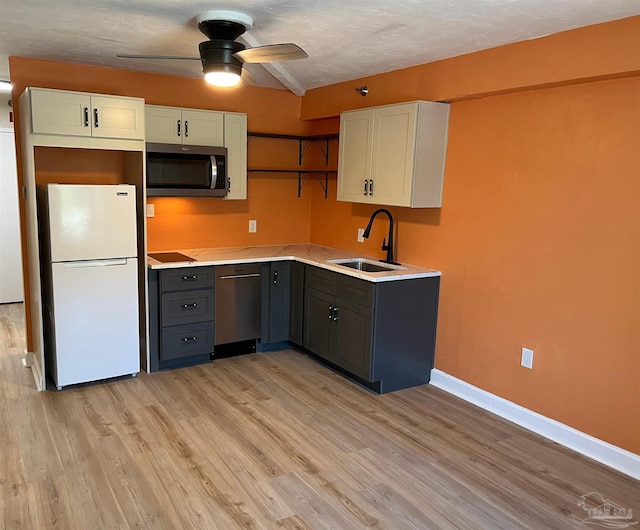 kitchen with light hardwood / wood-style flooring, stainless steel appliances, sink, gray cabinets, and ceiling fan