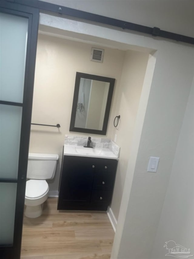 bathroom featuring hardwood / wood-style flooring, toilet, and vanity