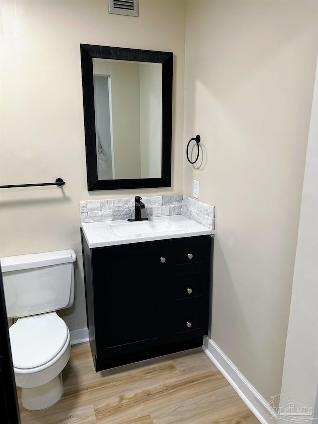 bathroom with vanity, wood-type flooring, and toilet