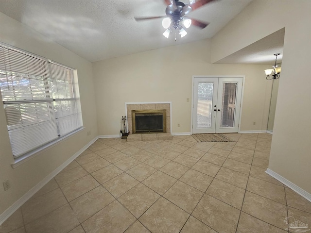 unfurnished living room featuring french doors, plenty of natural light, a fireplace, and light tile patterned floors