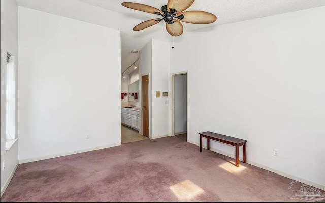 carpeted spare room with a textured ceiling, high vaulted ceiling, and ceiling fan