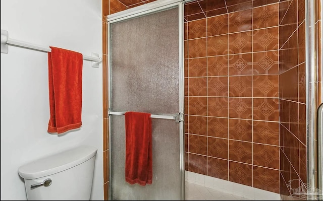 bathroom with toilet and a shower with door