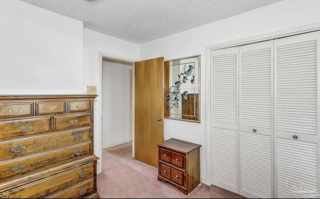 carpeted bedroom featuring a textured ceiling and a closet