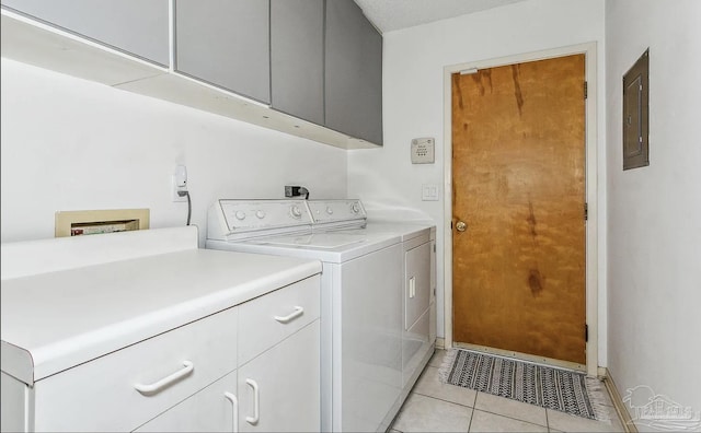 washroom featuring light tile patterned flooring, cabinets, independent washer and dryer, and electric panel