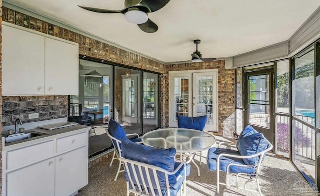 sunroom / solarium with ceiling fan and sink