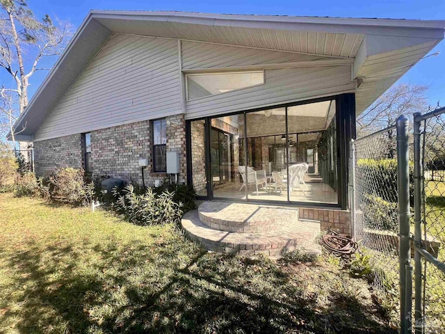 back of property with a yard and a sunroom