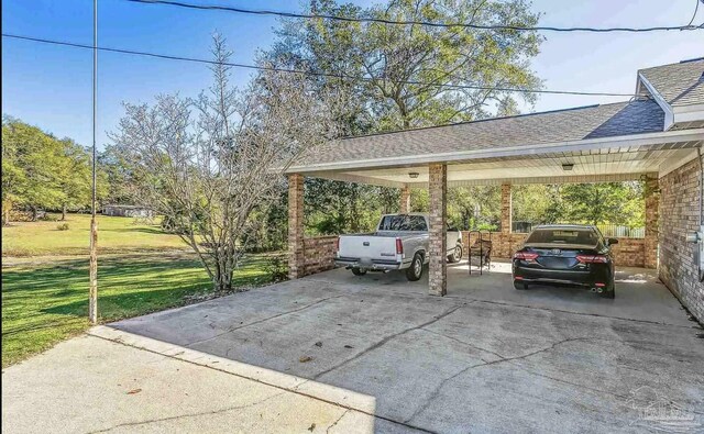 view of parking / parking lot with a yard and a carport