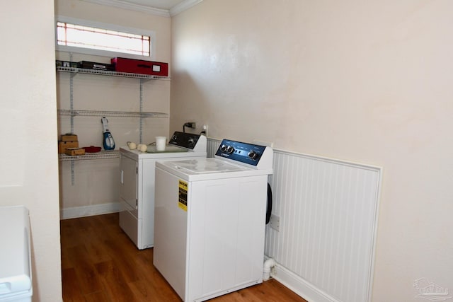 laundry room with washer and clothes dryer, wood-type flooring, and ornamental molding