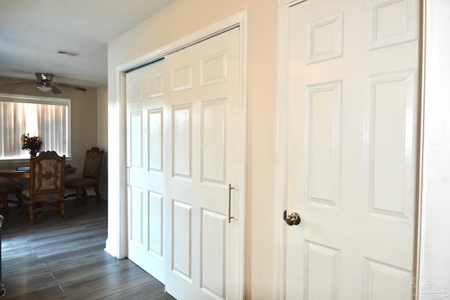 hall with a textured ceiling and dark hardwood / wood-style flooring