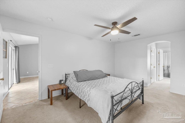 carpeted bedroom featuring a textured ceiling and ceiling fan