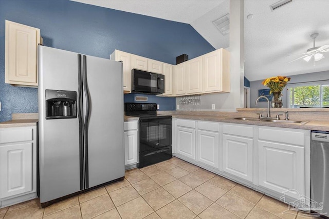 kitchen with white cabinetry, vaulted ceiling, black appliances, and sink