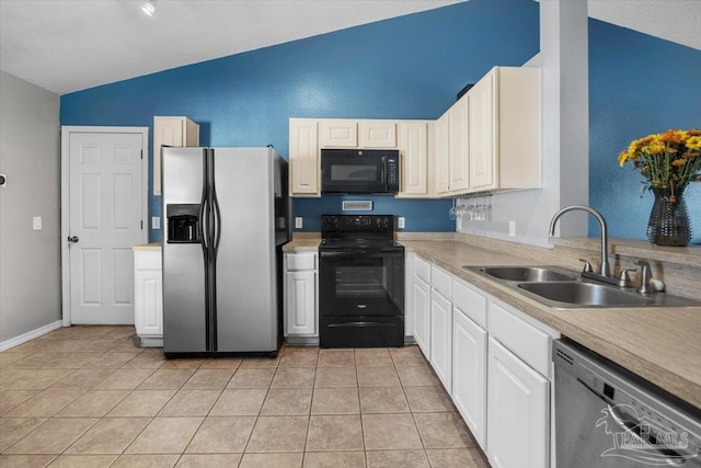 kitchen featuring vaulted ceiling, black appliances, sink, and light tile patterned floors