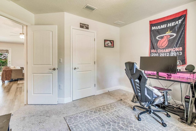 carpeted office with a textured ceiling