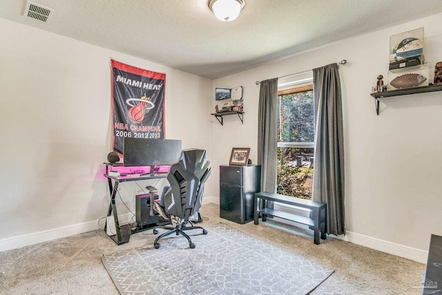 carpeted home office with a textured ceiling