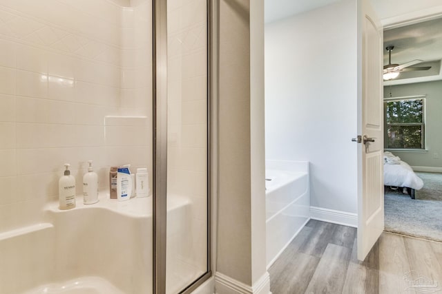 bathroom with hardwood / wood-style flooring, separate shower and tub, and ceiling fan