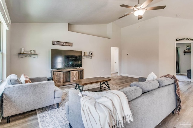 living room featuring wood-type flooring, vaulted ceiling, and ceiling fan