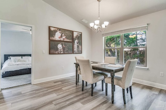 dining area featuring light wood-type flooring, a notable chandelier, and lofted ceiling