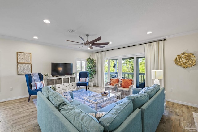 living area with crown molding, baseboards, and wood finished floors