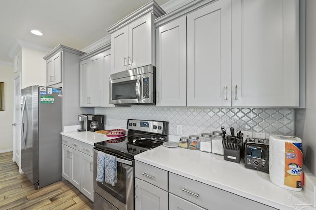 kitchen with stainless steel appliances, backsplash, and gray cabinetry