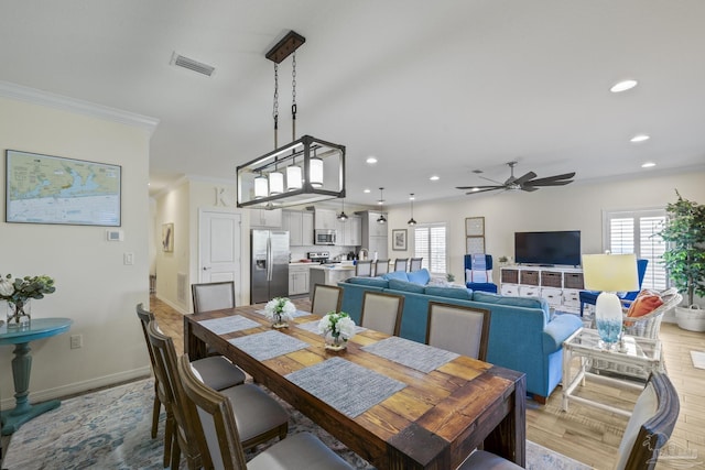 dining space featuring plenty of natural light, wood finished floors, visible vents, and crown molding