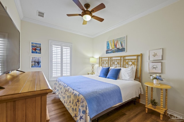 bedroom with wood finished floors, a ceiling fan, baseboards, visible vents, and crown molding