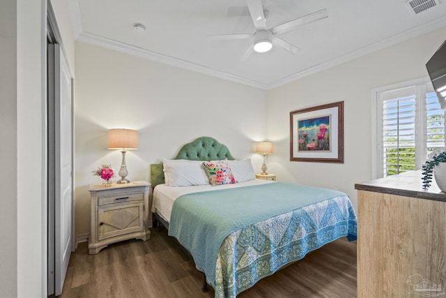 bedroom featuring a ceiling fan, crown molding, visible vents, and dark wood-type flooring