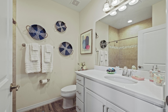 full bath featuring visible vents, toilet, vanity, wood finished floors, and baseboards