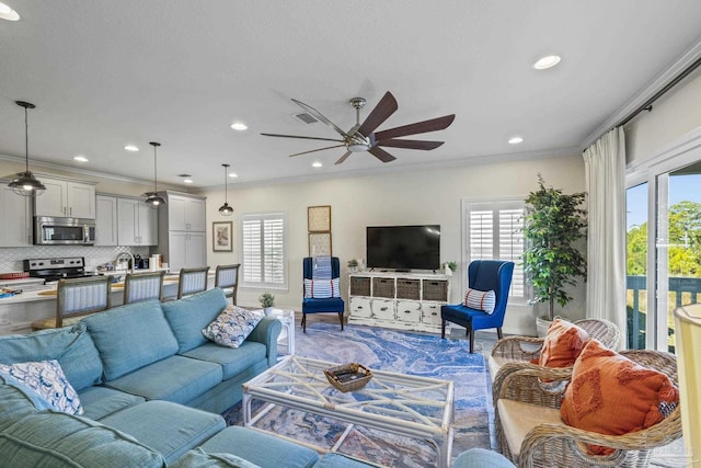 living area with ornamental molding, recessed lighting, visible vents, and a ceiling fan