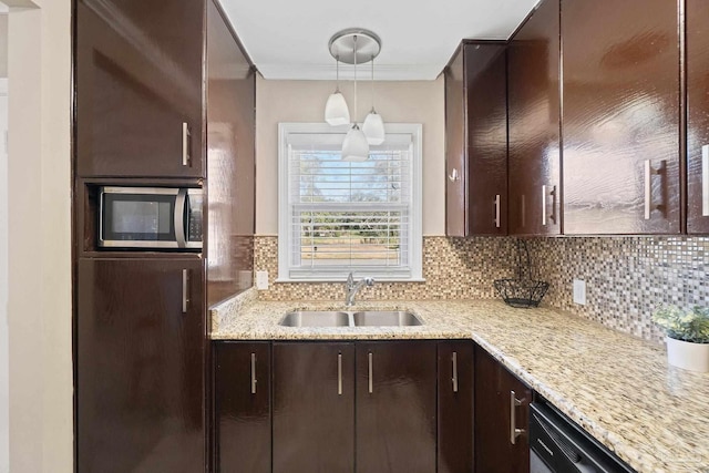 kitchen featuring dark brown cabinets, decorative backsplash, sink, and decorative light fixtures