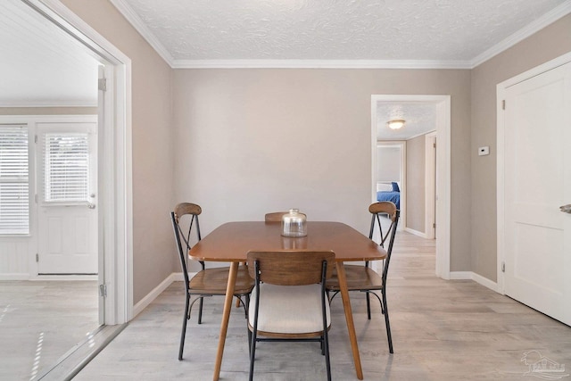 dining room featuring crown molding, a textured ceiling, and light hardwood / wood-style floors