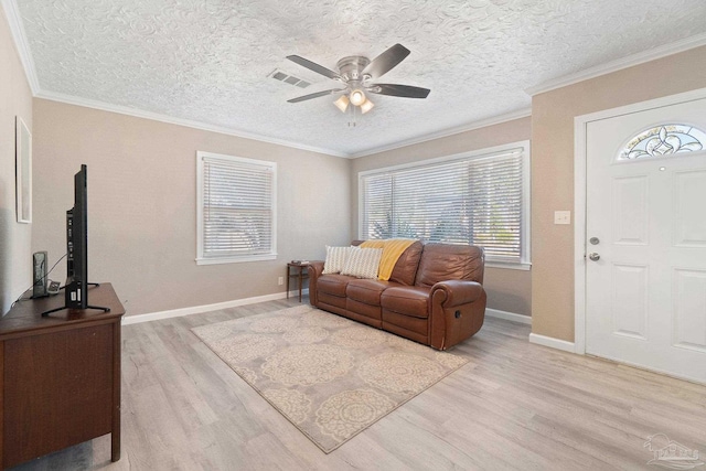 living room with light hardwood / wood-style floors, crown molding, a textured ceiling, and ceiling fan