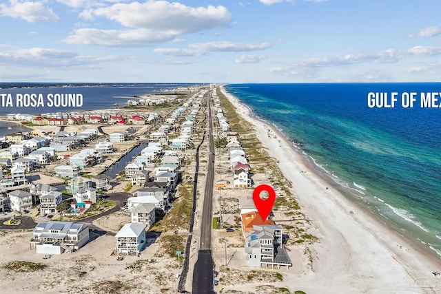 birds eye view of property with a water view and a beach view