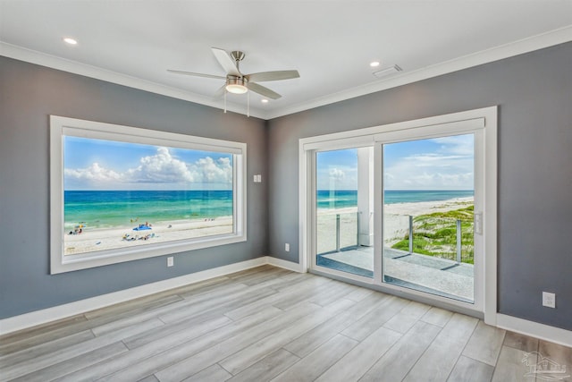 interior space featuring a view of the beach, a water view, and crown molding