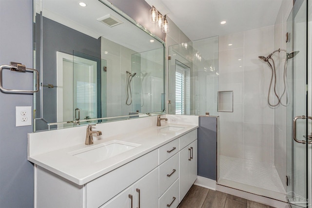 bathroom featuring hardwood / wood-style flooring, vanity, and an enclosed shower