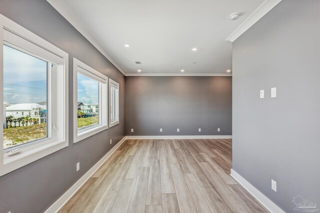 empty room featuring crown molding and light wood-type flooring