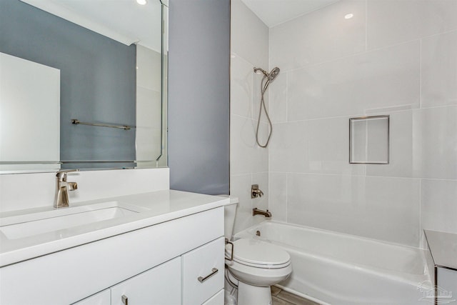 full bathroom featuring vanity, tiled shower / bath combo, and toilet