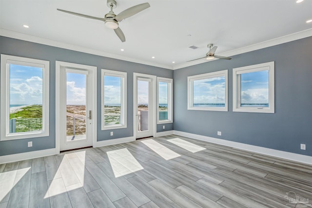 spare room featuring crown molding, ceiling fan, and light hardwood / wood-style flooring