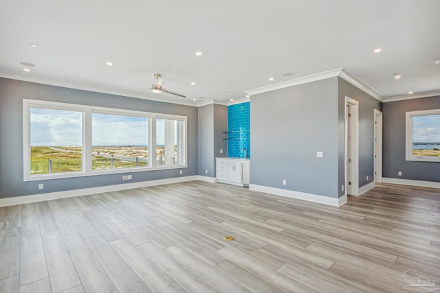 unfurnished living room featuring ceiling fan, ornamental molding, and light hardwood / wood-style flooring