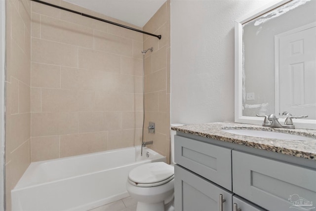 full bathroom featuring tiled shower / bath, vanity, toilet, and tile patterned floors