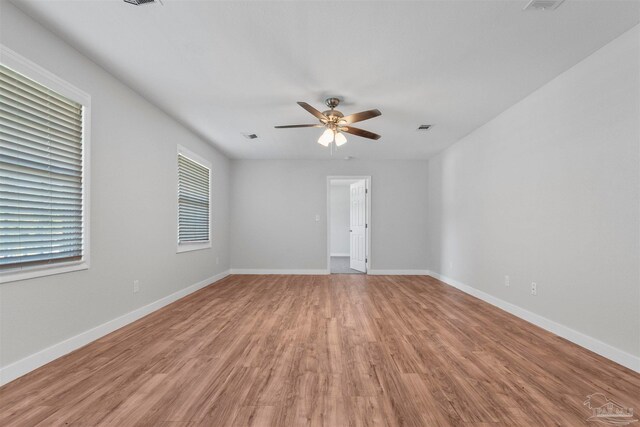 spare room with ceiling fan, light hardwood / wood-style floors, and a healthy amount of sunlight