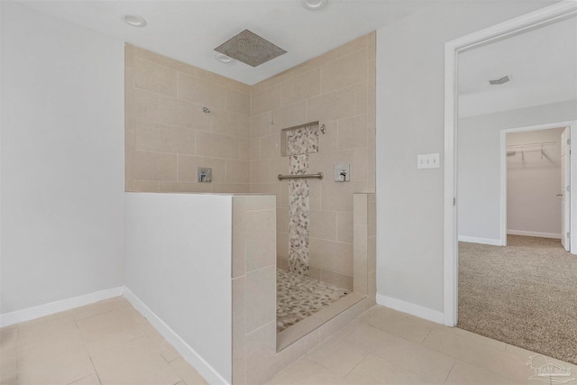 bathroom with a tile shower and tile patterned floors