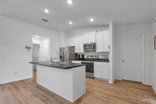 4695 Perception Cir, Milton, FL 32570 - kitchen featuring appliances with stainless steel finishes, dark countertops, a sink, vaulted ceiling, and white cabinetry