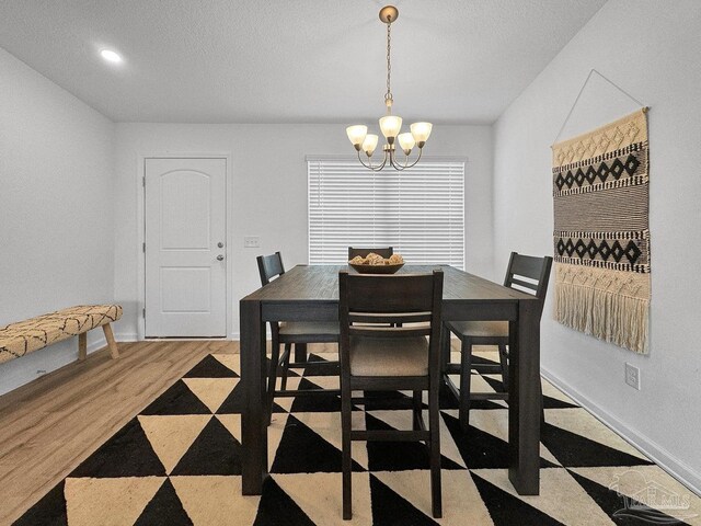 4695 Perception Cir, Milton, FL 32570 - dining room featuring a chandelier, baseboards, and wood finished floors
