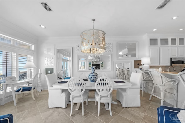 dining area featuring an inviting chandelier, crown molding, and light tile patterned floors