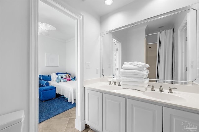 bathroom featuring tile patterned flooring, vanity, walk in shower, and toilet