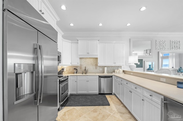 kitchen featuring white cabinetry, decorative backsplash, ornamental molding, light tile patterned floors, and stainless steel appliances