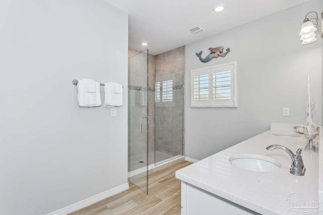 14390 Cordgrass Ln, Pensacola, FL 32507 - full bathroom with wood finished floors, baseboards, double vanity, a sink, and a shower stall