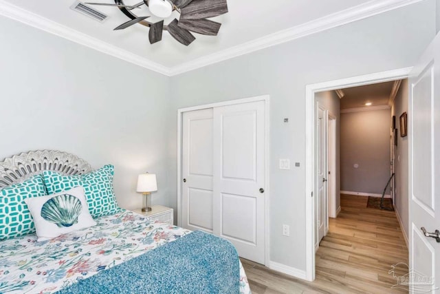 14390 Cordgrass Ln, Pensacola, FL 32507 - bedroom featuring light wood finished floors, visible vents, crown molding, baseboards, and a closet