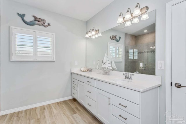 14390 Cordgrass Ln, Pensacola, FL 32507 - bathroom featuring a sink, baseboards, a stall shower, and wood finished floors