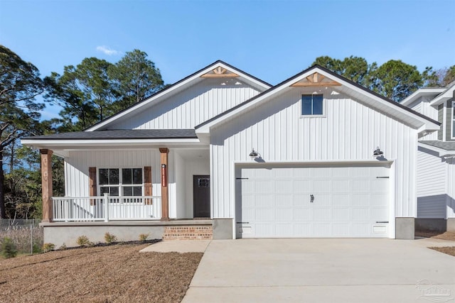 modern inspired farmhouse with a shingled roof, a porch, an attached garage, board and batten siding, and driveway